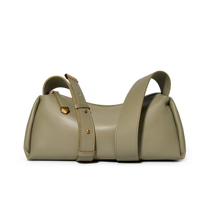 Green cowhide pillow crossbody bag with wide adjustable strap on white background