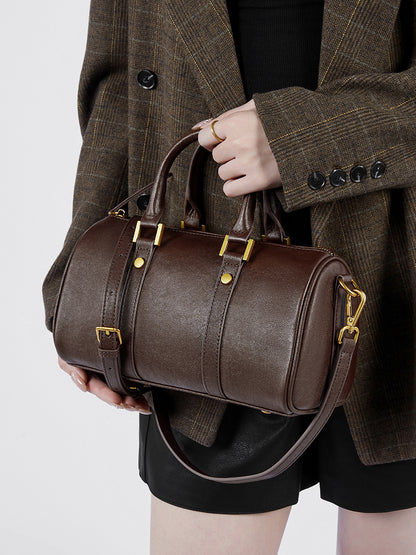 Front view of dark brown leather Boston bag with gold-tone hardware