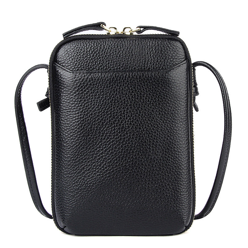Black pebbled cowhide vertical crossbody phone bag with top zip and adjustable strap