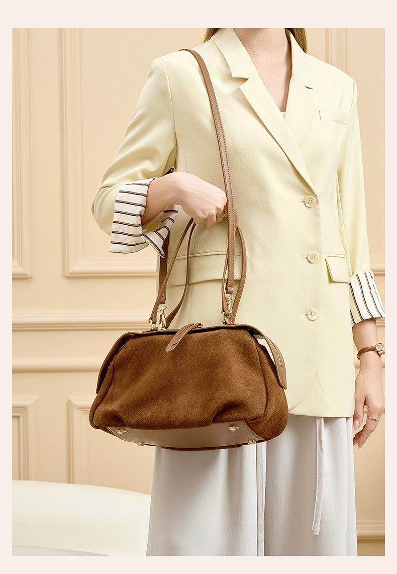 Model holding the shoulder bag against a light outfit