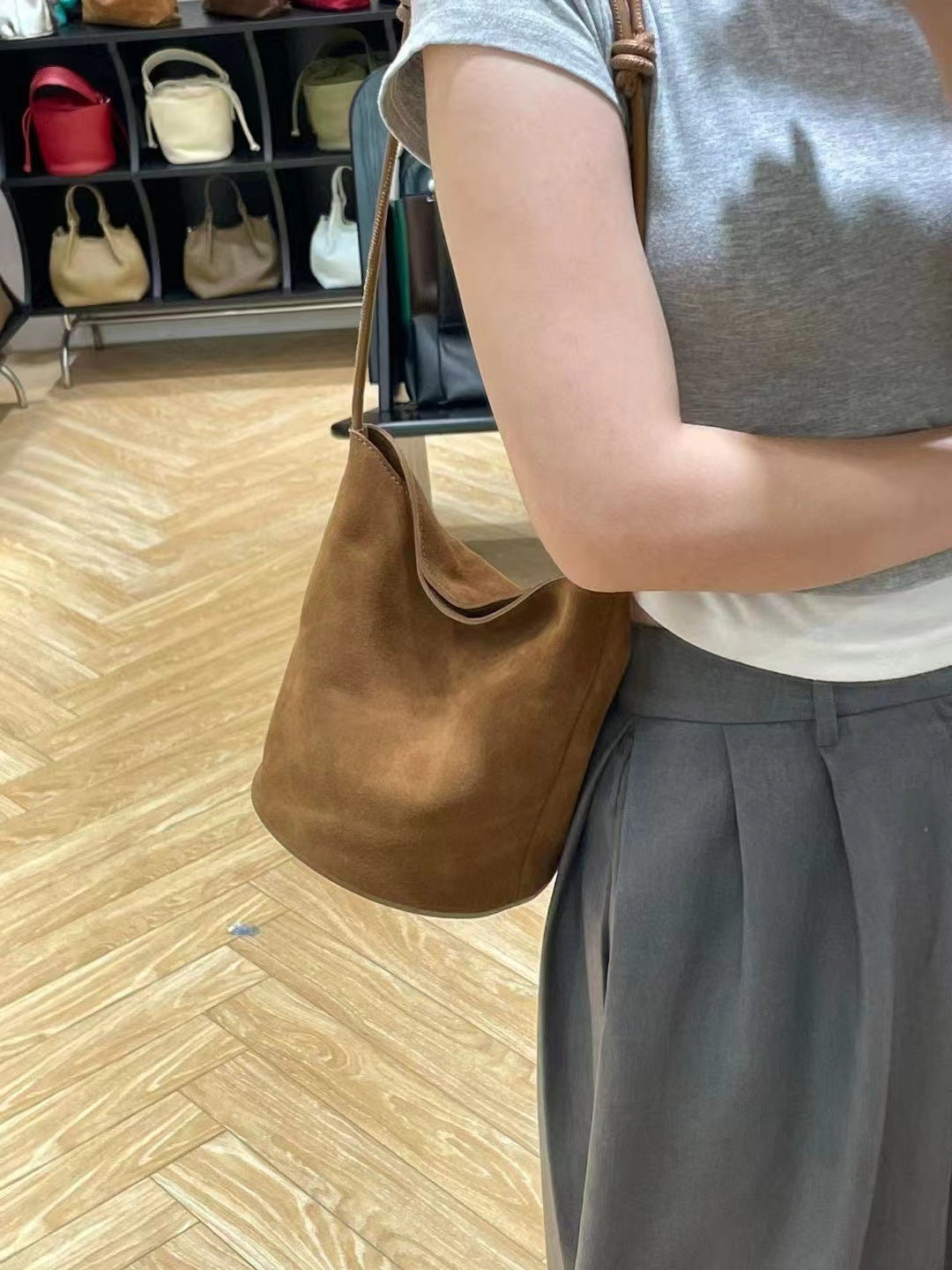Brown suede shoulder bag worn over the shoulder