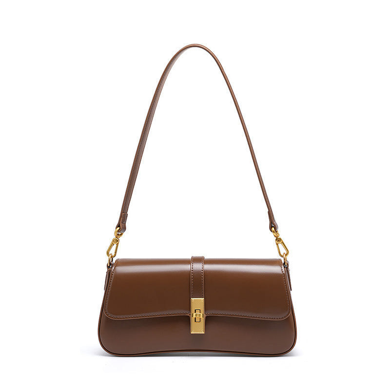 Brown cowhide leather mini baguette shoulder bag with gold-tone turn-lock closure on white background