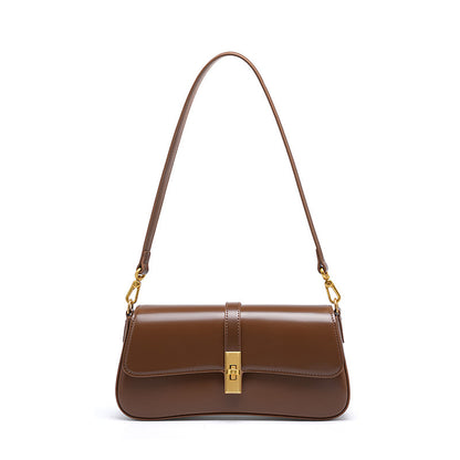 Brown cowhide leather mini baguette shoulder bag with gold-tone turn-lock closure on white background