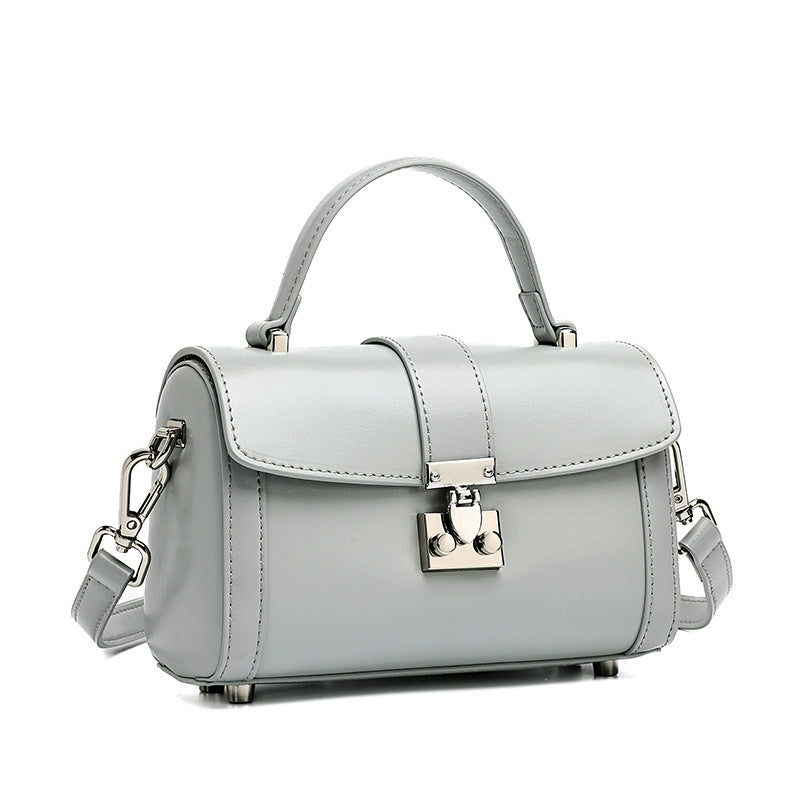 Light blue cowhide leather mini box crossbody bag with lock clasp on white background