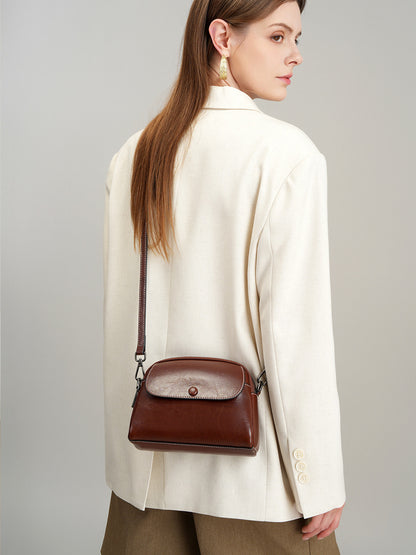 Side view of model with dark brown crossbody bag hanging at hip