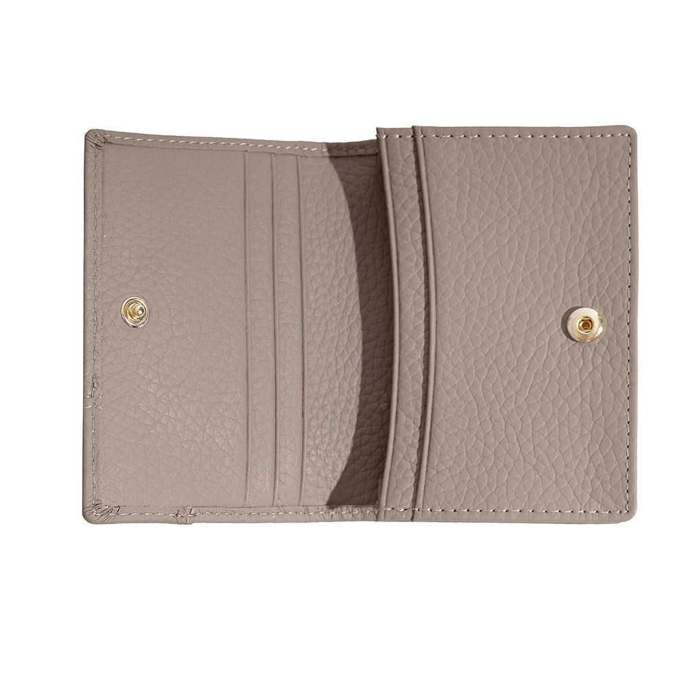 Open empty interior of light grey cowhide card holder showing card slots and snap
