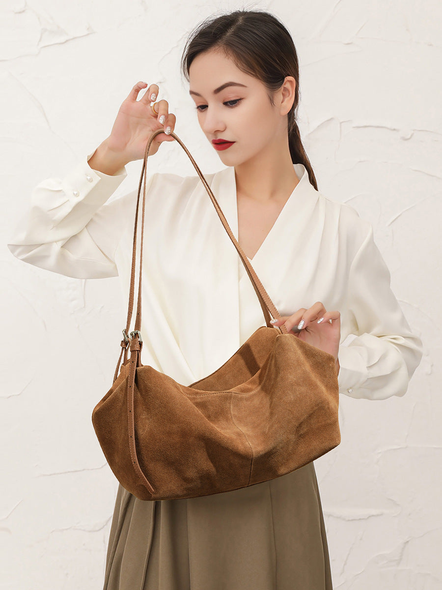 Model holding caramel-colored suede cowhide tote