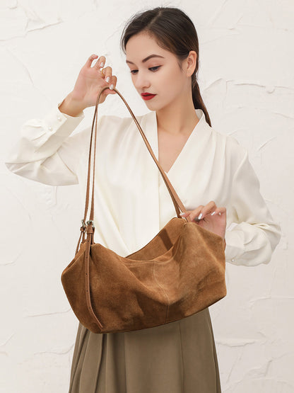 Model holding caramel-colored suede cowhide tote