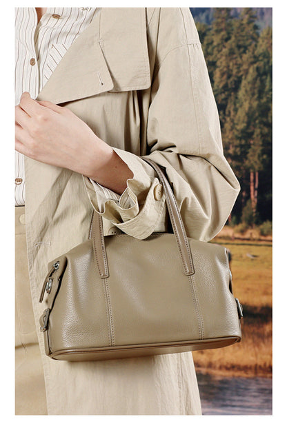 Close-up of model holding elephant gray bag in beige outfit