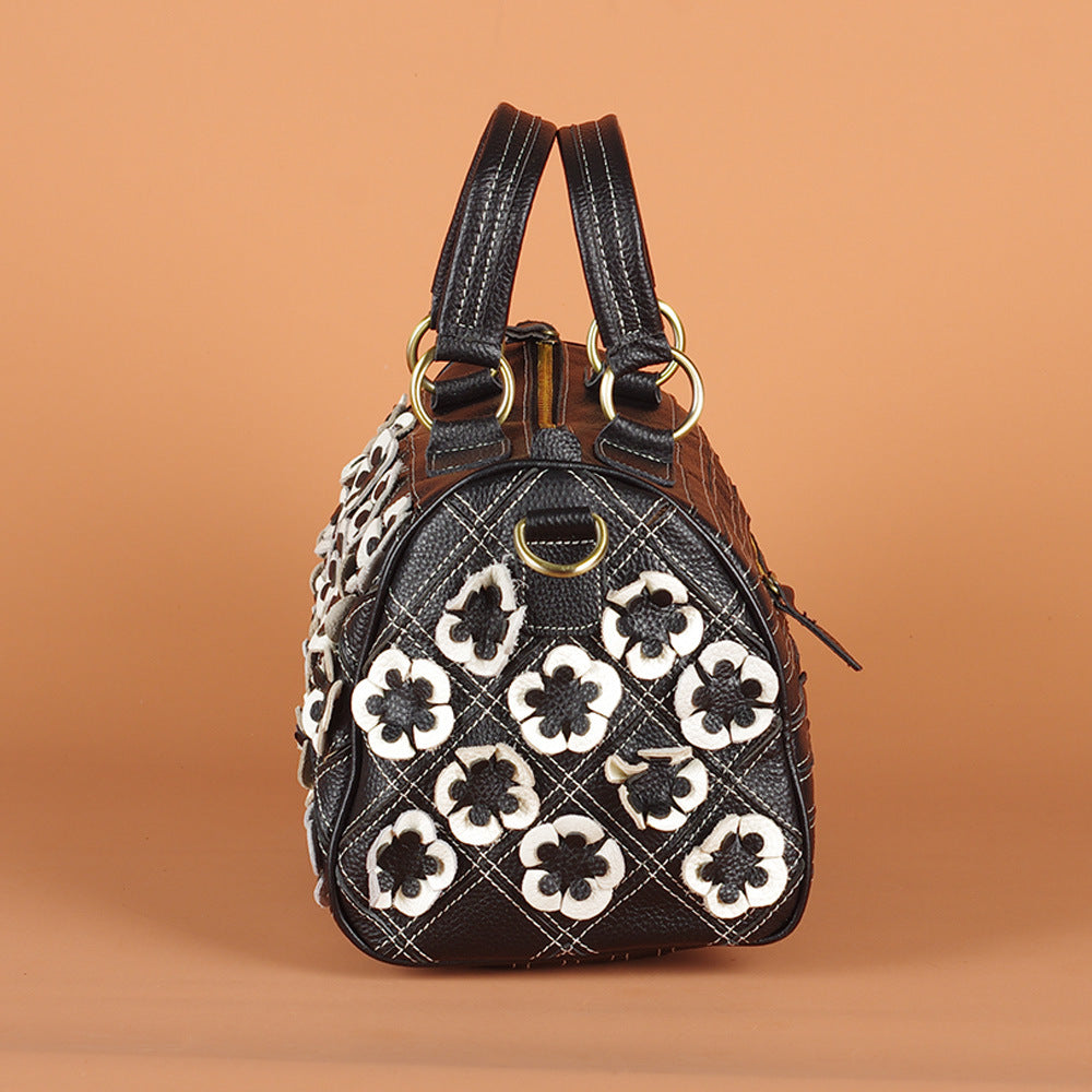 End panel view of black cowhide bag with raised flower details