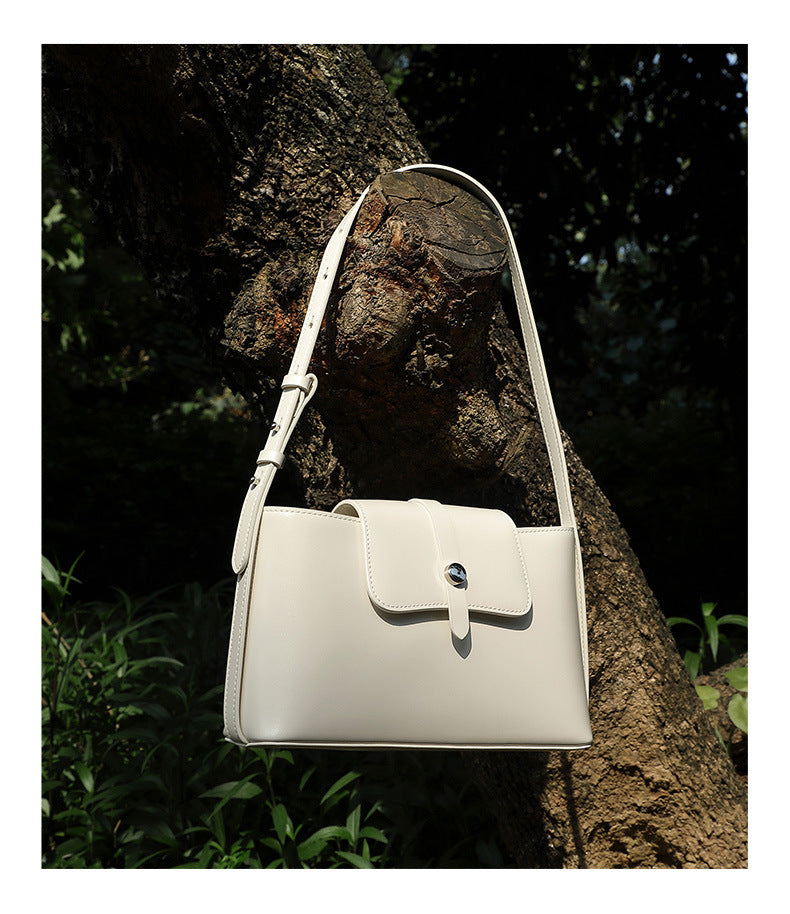 Red leather bag hanging on tree branch close-up