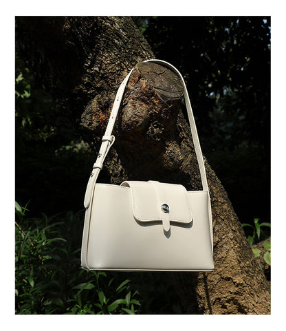 Red leather bag hanging on tree branch close-up