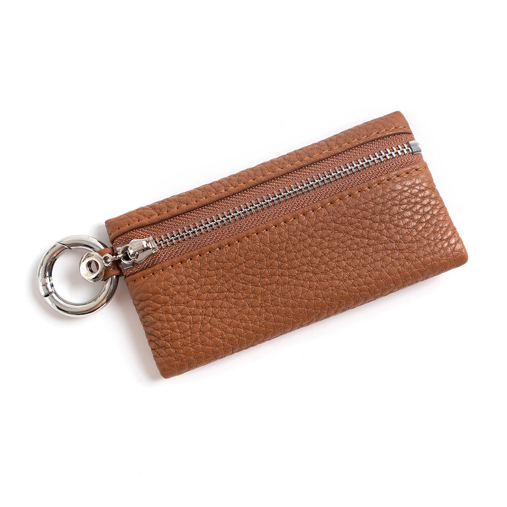 Caramel top-grain leather coin purse with polished keyring, angled view