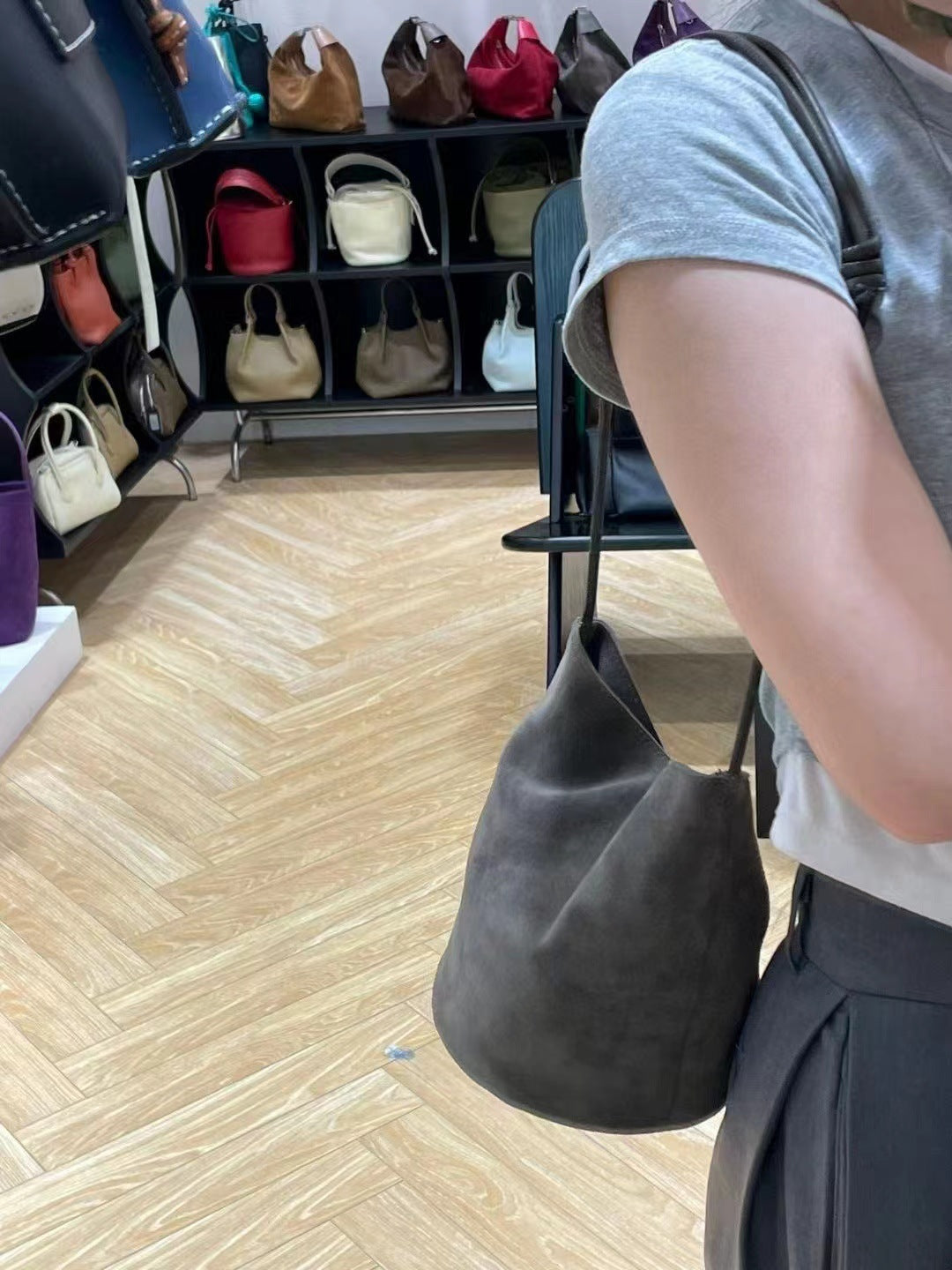Gray bucket bag worn at the side