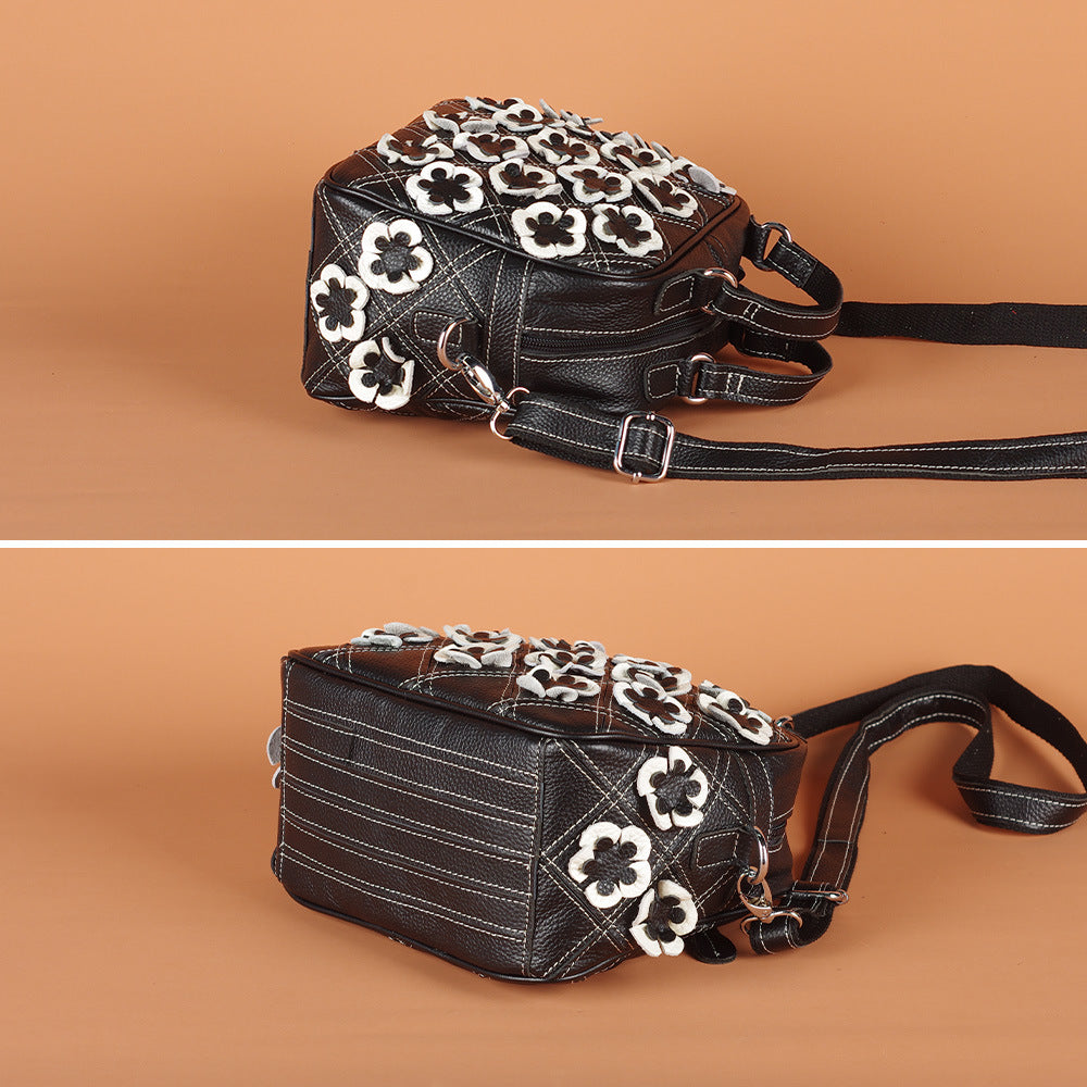 Close-up of top handles and zipper on the black floral shoulder bag