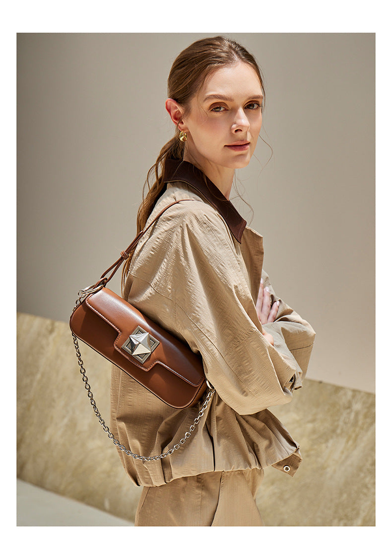 Model wearing caramel leather baguette shoulder bag, side view