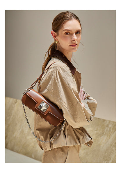 Model wearing caramel leather baguette shoulder bag, side view
