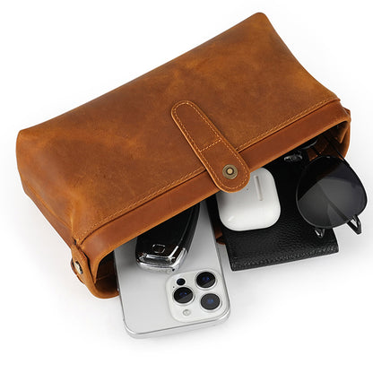 Open brown cowhide pouch with phone keys coins and sunglasses