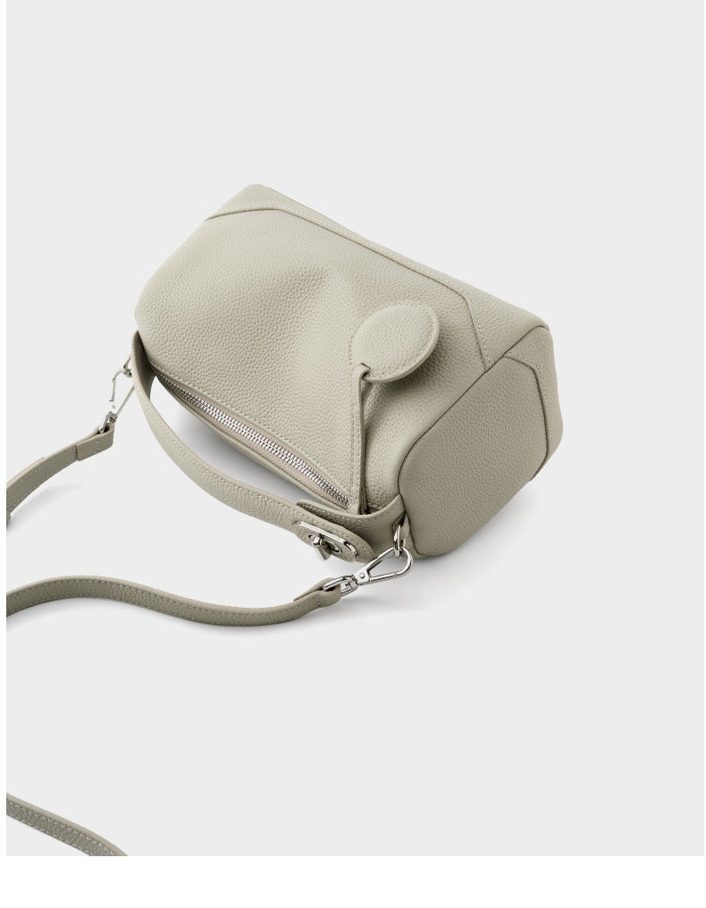 Top-down angle view of ash white mini Boston bag with zip closure