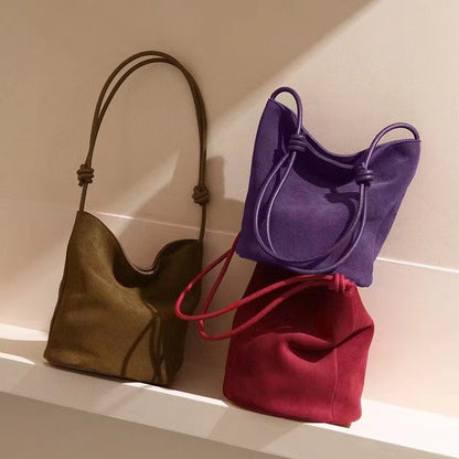 Purple and red bucket bags arranged with a brown style