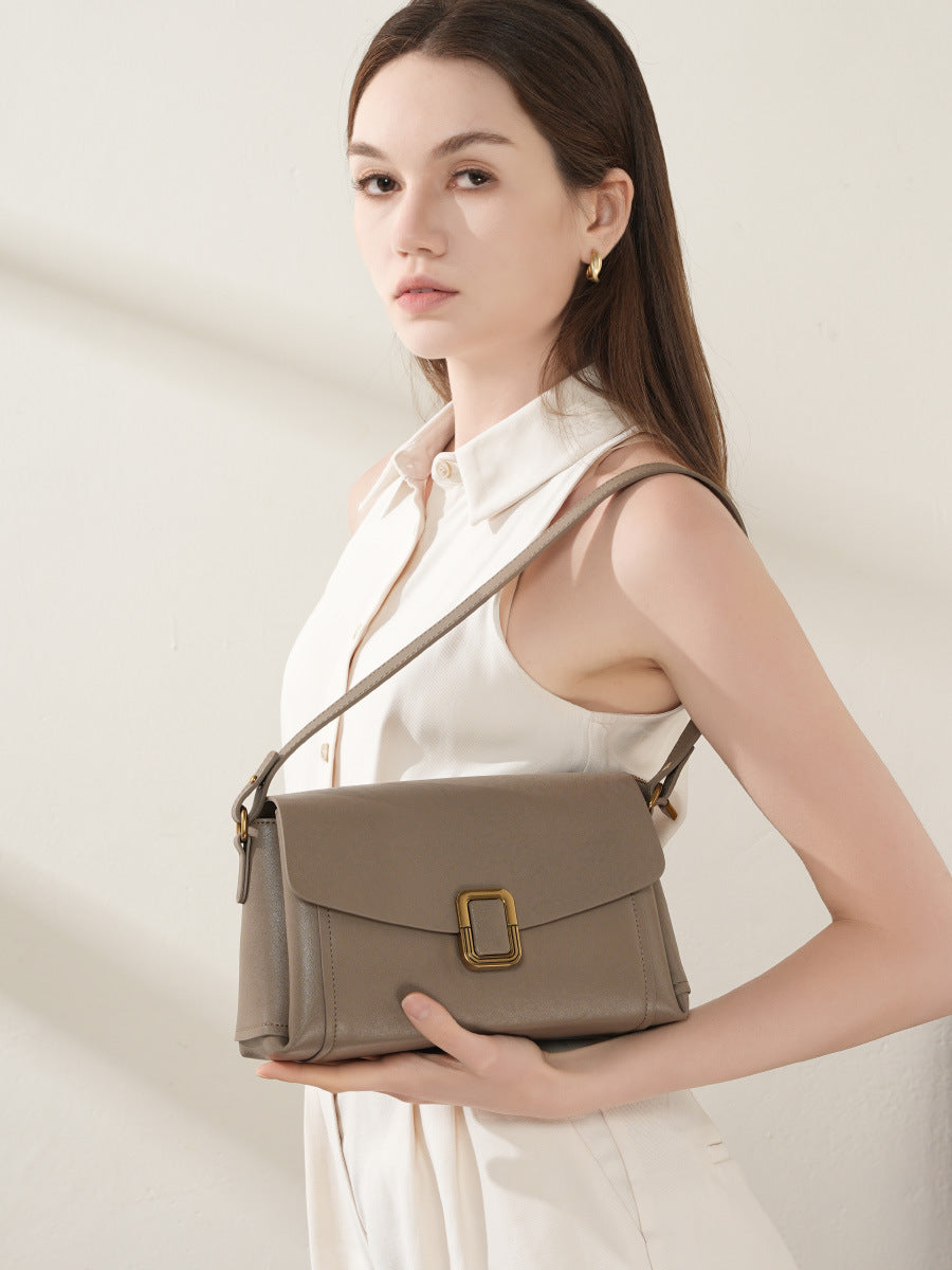 Model wearing gray cowhide leather crossbody bag across the body