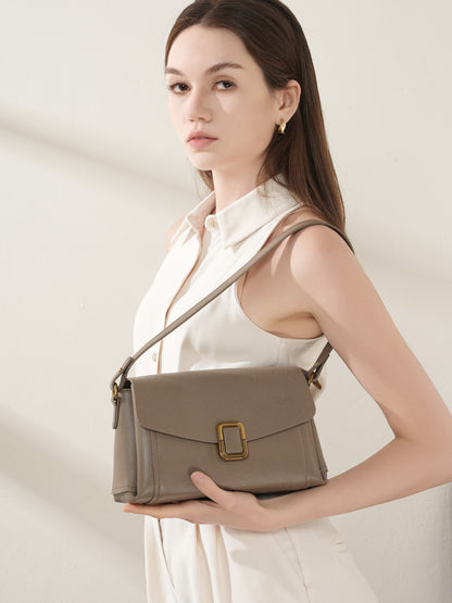 Model wearing gray cowhide leather crossbody bag across the body