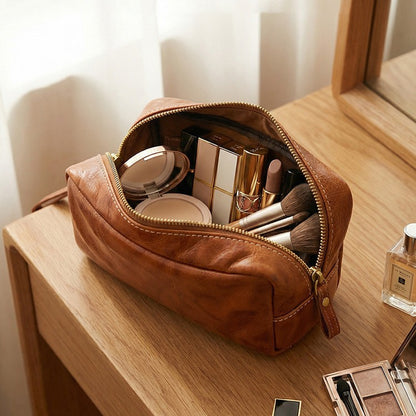 Angled close-up of leather pouch with open zip compartment