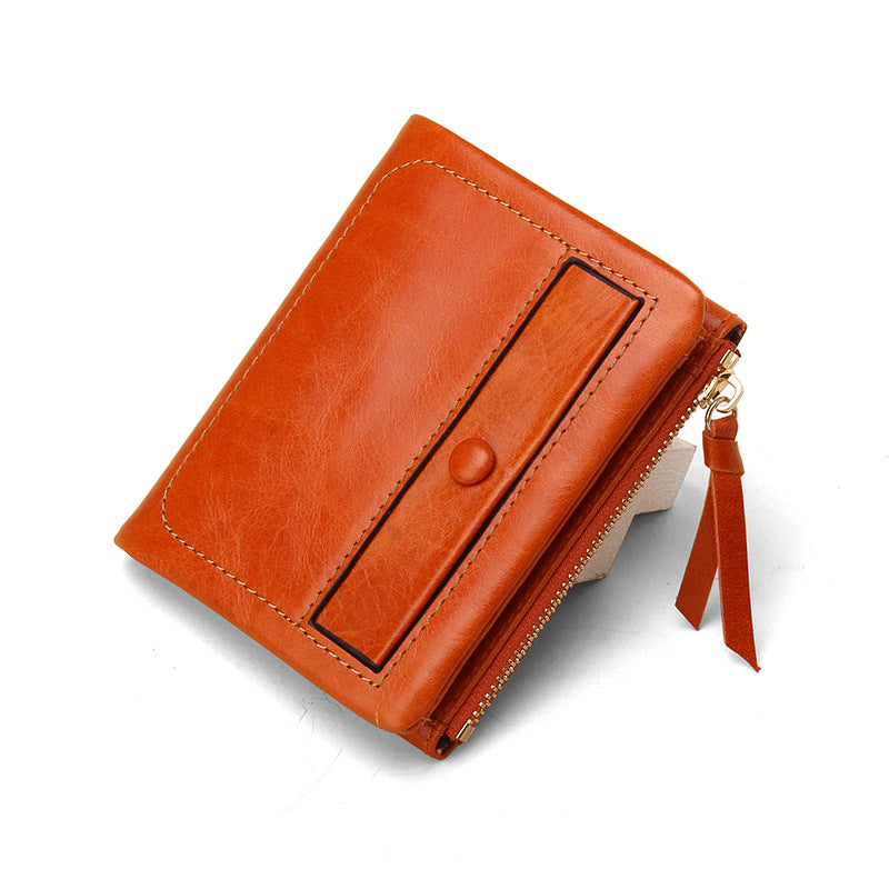 Orange top-grain cowhide vintage short wallet at an angle displaying the zippered coin pocket and side profile
