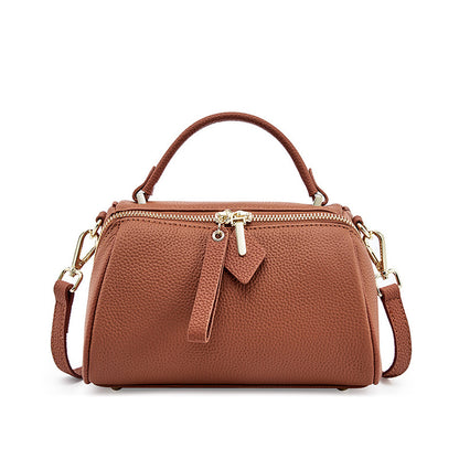 Golden brown top-grain cowhide mini Boston bag with dual zip closure and adjustable strap