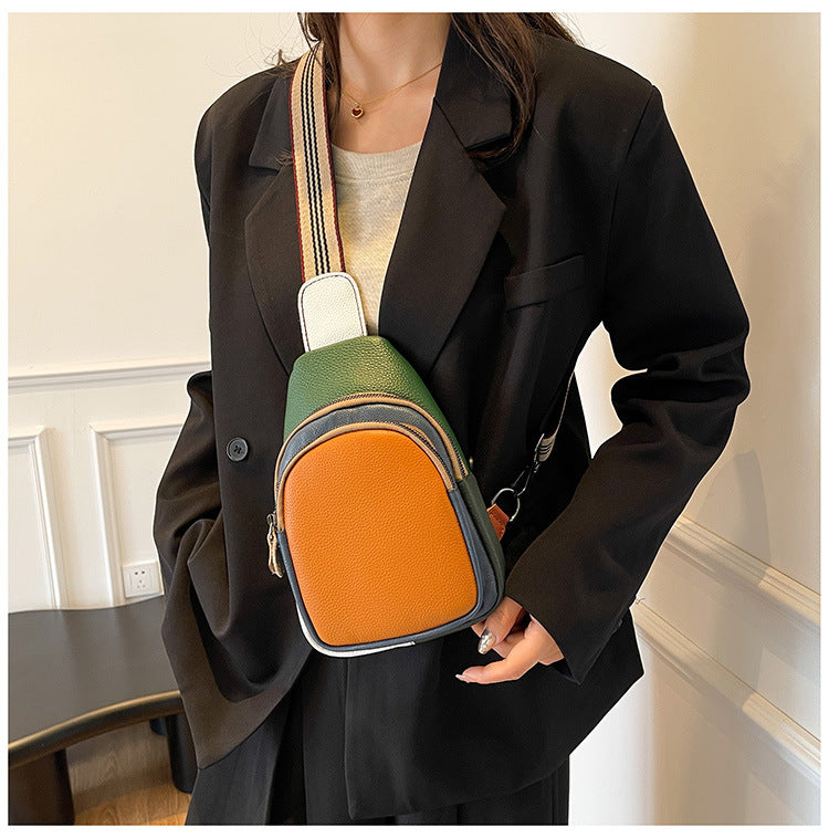 Orange and green sling bag worn across the front