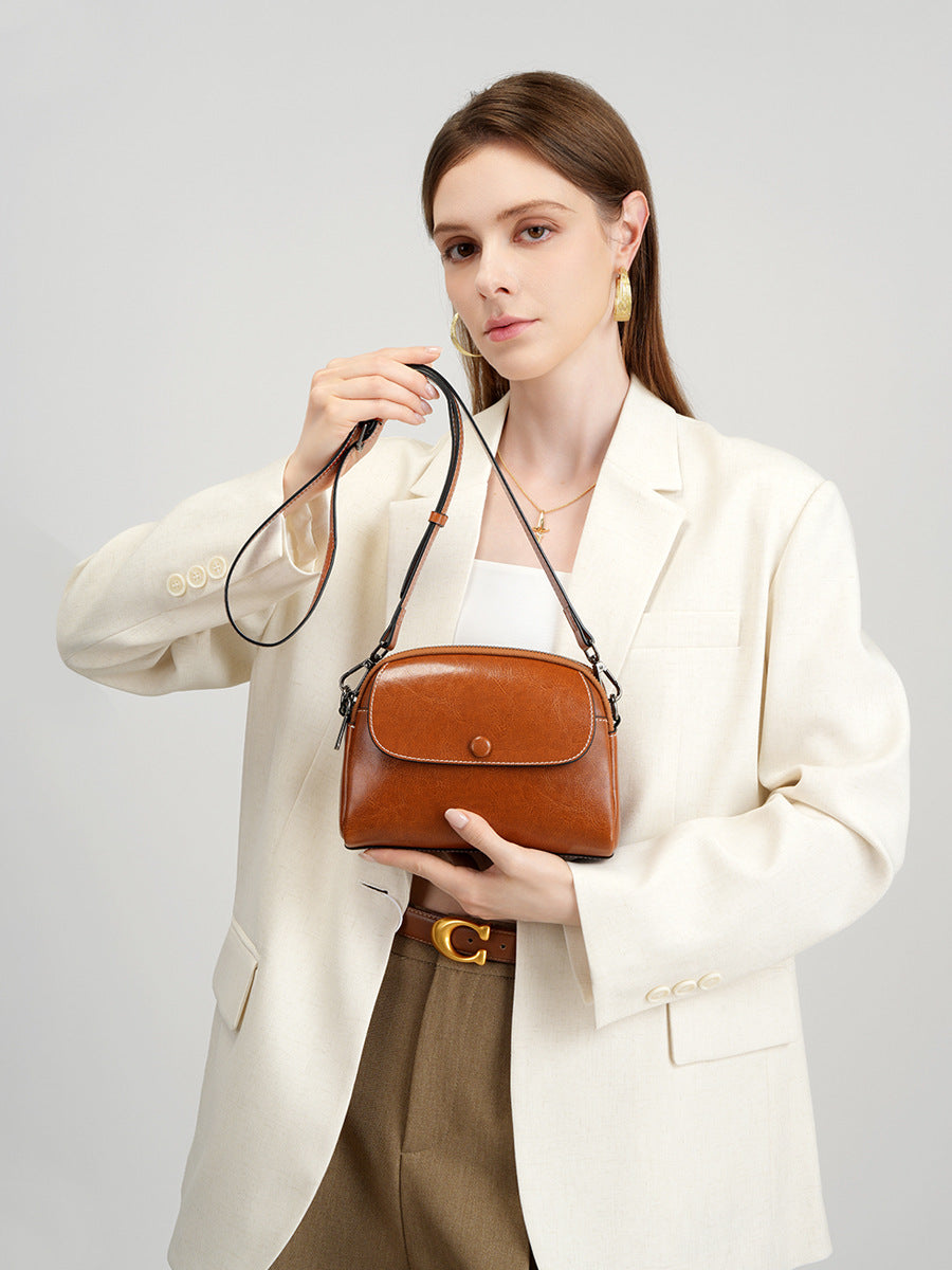 Model carrying caramel crossbody bag in front view