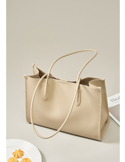 Salt beige leather tote bag styled with books and a decorative plate