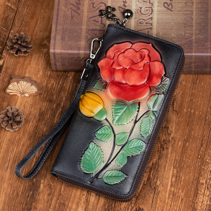 Black zip-around wallet with colorful floral embossing and wrist strap