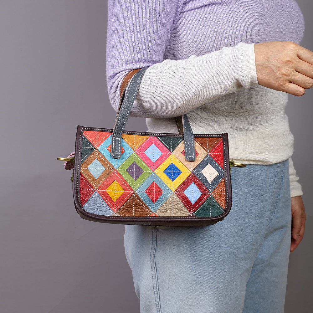 Multicolor geometric patchwork cowhide shoulder bag carried by its handles