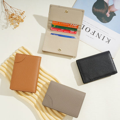 Flat lay of four cowhide card holders in tan, black, beige, and grey