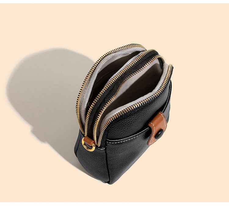 Black cowhide bag open showing interior polyester lining and zip pocket