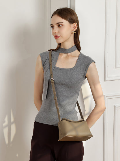 Model wearing a khaki pebbled leather crossbody bag with adjustable strap