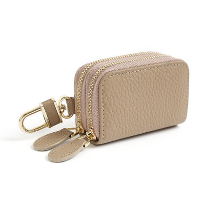 Light gray cowhide leather key case pouch with double zipper and gold-tone rotating clip on white background