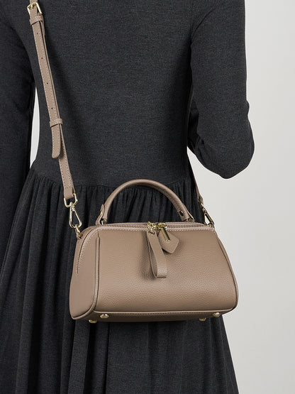 Model wearing gray mini Boston bag crossbody with adjustable leather strap