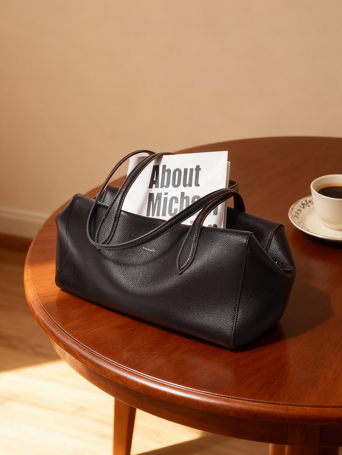 Dark brown cowhide tote displayed on a wooden table
