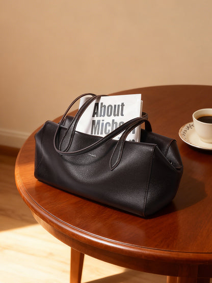 Dark brown cowhide tote displayed on a wooden table