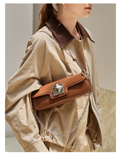Close-up of caramel leather baguette shoulder bag worn by a model