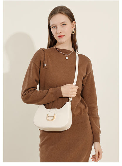 Model wearing cream white shoulder bag with crossbody strap