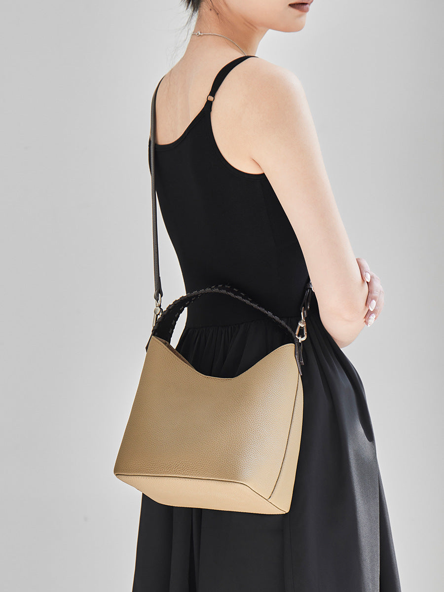 Grey leather bucket bag worn crossbody on a long strap