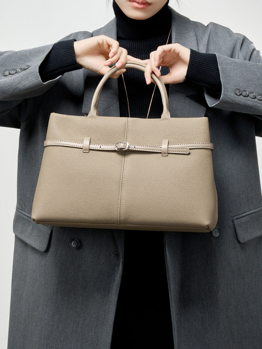 Model in gray blazer carrying elephant gray leather tote by top handles