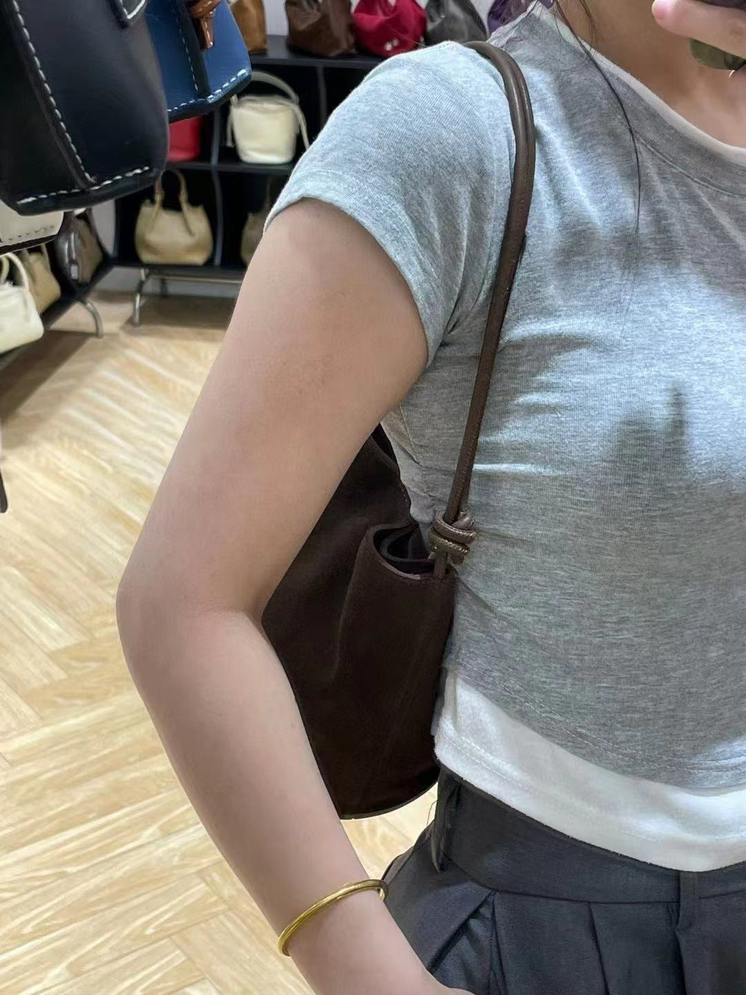 Dark brown bucket bag shown against an everyday outfit