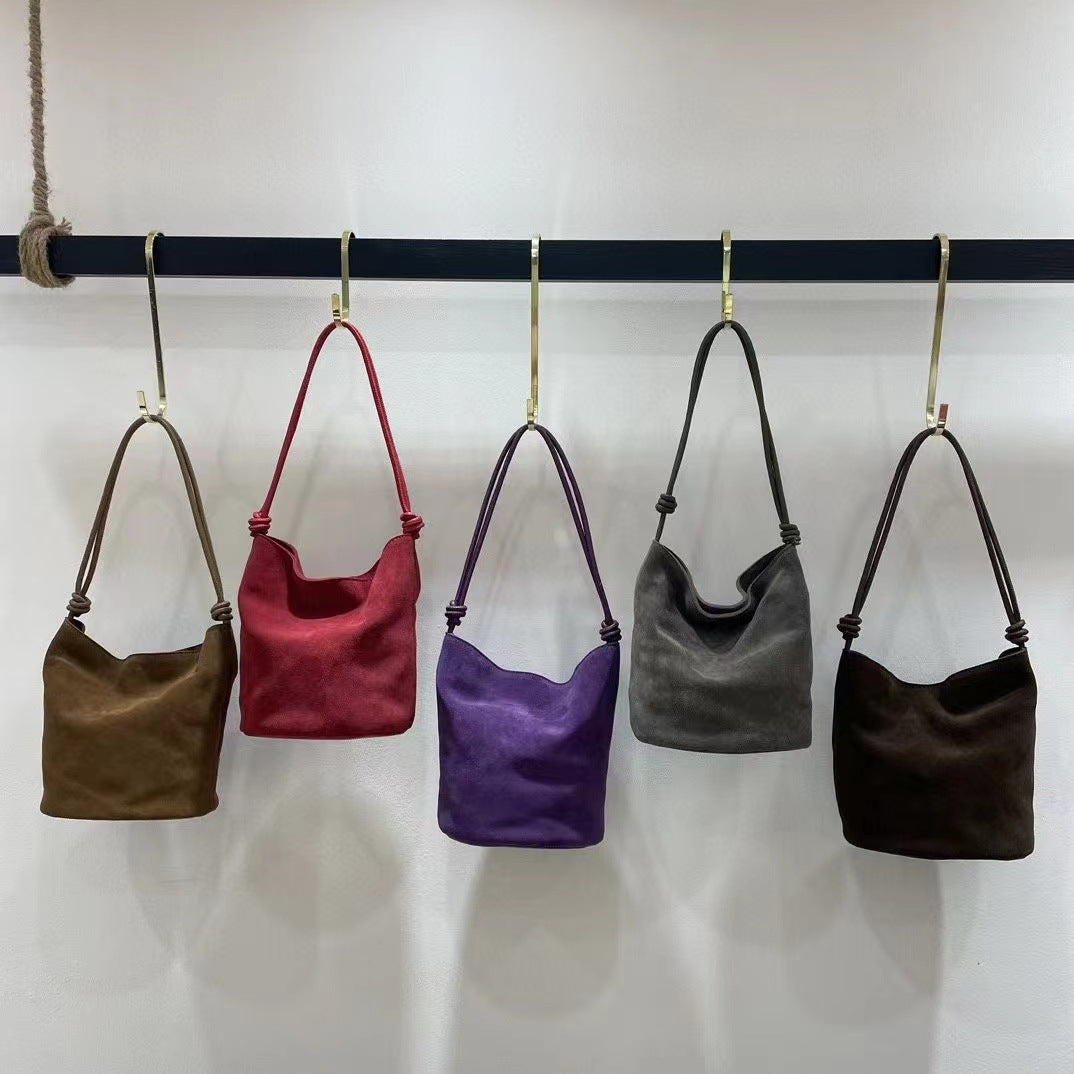 Five color options of the bucket shoulder bag hanging in a row