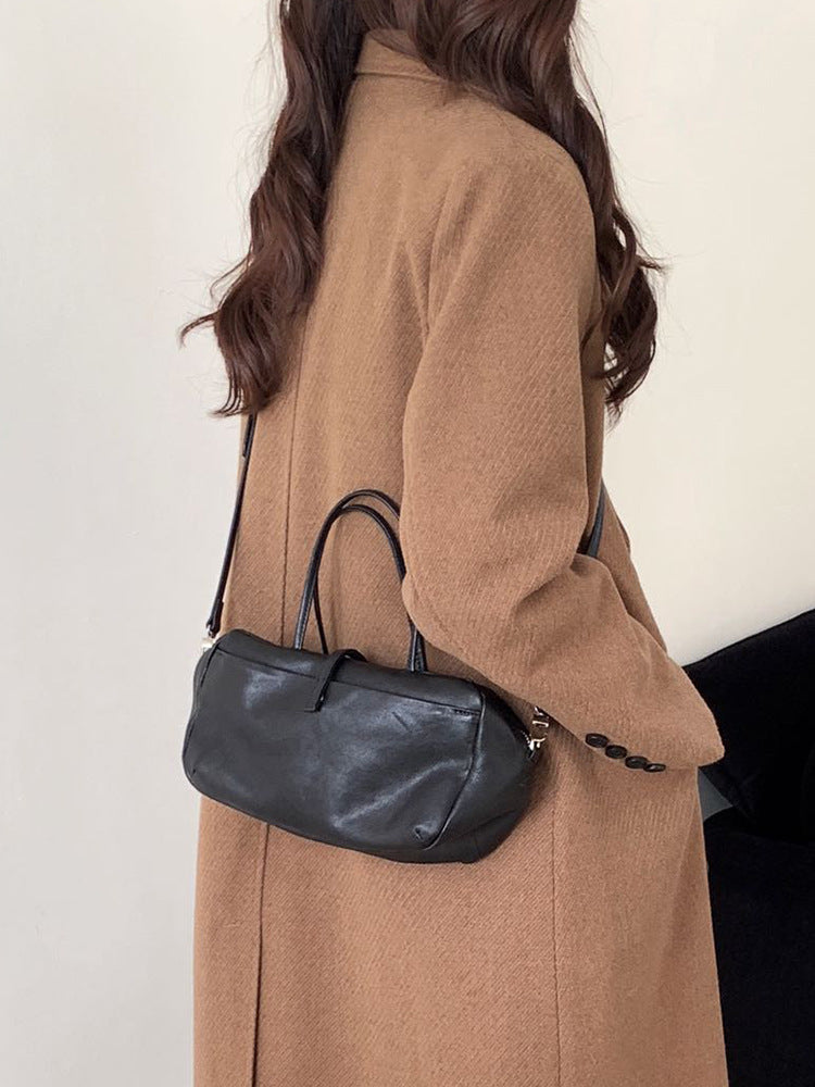 Black lambskin Boston bag worn over the shoulder