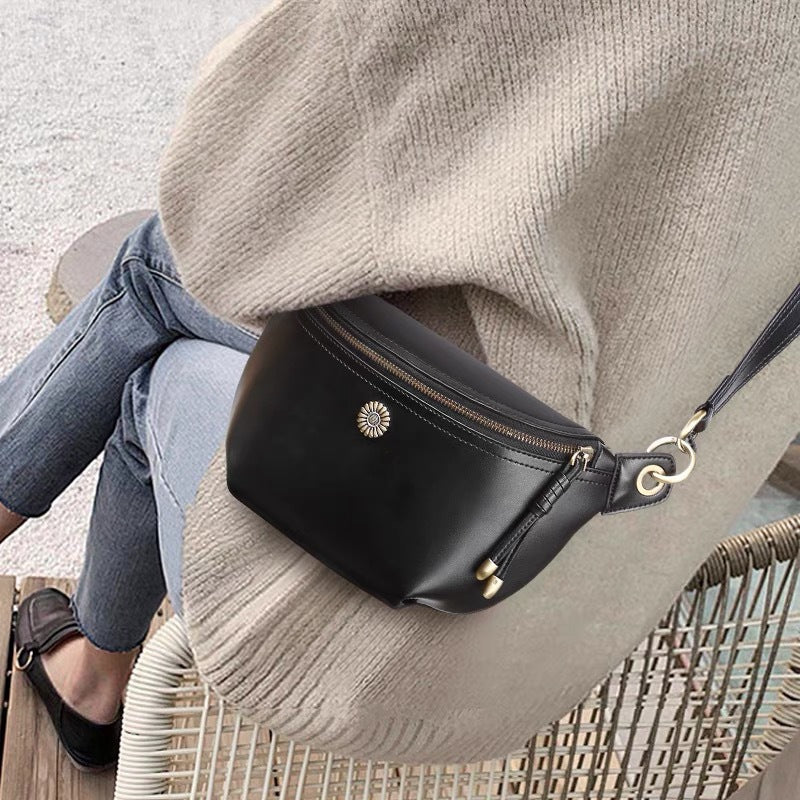 Black leather crossbody bag worn with a casual sweater and jeans