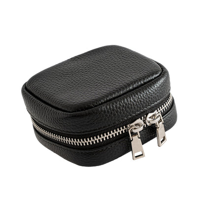 Angled view of black cowhide leather mini cosmetic pouch showing dual zipper pulls and pebbled texture